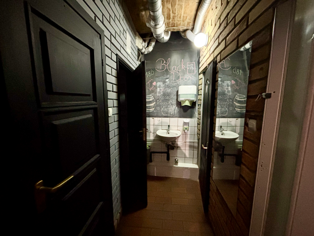 The Black Door Darts & Sport Bar restroom is located in downtown Budapest.